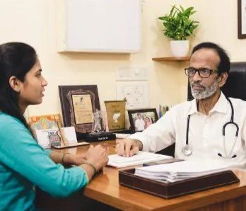 Dr. Kishore Nichani consulting a patient at his desk